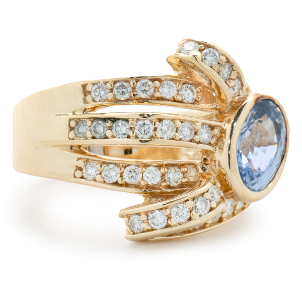14 Karat Yellow Gold Bezel Set Cornflower Blue Sapphire and Diamond Bypass Ring